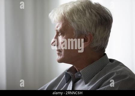 Thoughtful elder mature hoary man looking away in deep thoughts Stock Photo
