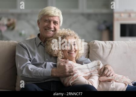 Happy joyful relaxed mature grey haired couple home portrait Stock Photo