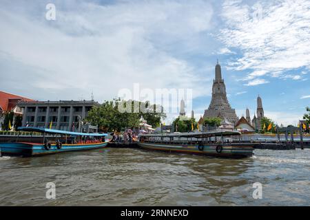 Chao Praya, Thailand - June 1, 2019: Scenic view of Wat Arun from the Chao Praya River of Bangkok, Thailand. - Wat Arun with longtail boats and touris Stock Photo