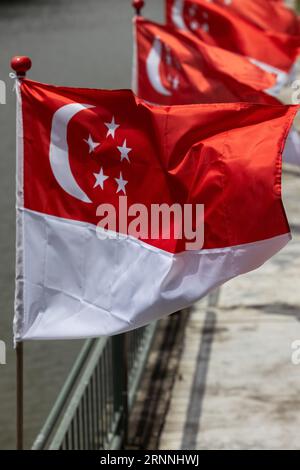 Several Singaporean flags are fluttering in the wind. Stock Photo