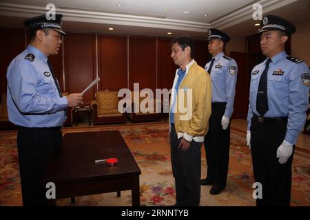 (170729) -- BEIJING, July 29, 2017 -- A policeman reads an arrest warrant to Ren Biao at Beijing Capital International Airport in Beijing, capital of China, July 29, 2017. Ren Biao, one of China s most wanted fugitives, has returned to China and turned himself in to the police, the anti-corruption authority said Saturday. Ren, 44, former actual controlling shareholder of Daluo energy supplies company in east China s Jiangsu Province, fled to the Caribbean nation of Saint Kitts and Nevis in January 2014 after being accused of fraudulently obtaining loans and fabricating financial bills, accordi Stock Photo