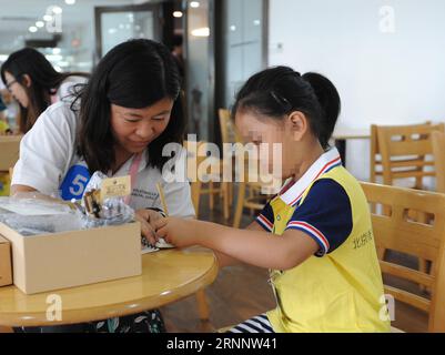 (170729) -- BEIJING, July 29, 2017 -- A volunteer helps an autistic child in drawing a picture during an interactive game in a campaign to show love to the autistic children in Beijing July 29, 2017. ) (clq) CHINA-BEIJING-AUTISTIC CHILDREN-CARE(CN) RenxPengfei PUBLICATIONxNOTxINxCHN   Beijing July 29 2017 a Volunteer Helps to Autistic Child in drawing a Picture during to Interactive Game in a Campaign to Show Love to The Autistic Children in Beijing July 29 2017 CLQ China Beijing Autistic Children Care CN RenxPengfei PUBLICATIONxNOTxINxCHN Stock Photo