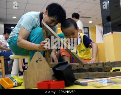 (170729) -- BEIJING, July 29, 2017 -- An adult helps an autistic child assembling a piece of furniture during an interactive game in a campaign to show love to the autistic children in Beijing July 29, 2017. ) (clq) CHINA-BEIJING-AUTISTIC CHILDREN-CARE(CN) RenxPengfei PUBLICATIONxNOTxINxCHN   Beijing July 29 2017 to Adult Helps to Autistic Child Assembling a Piece of FURNITURE during to Interactive Game in a Campaign to Show Love to The Autistic Children in Beijing July 29 2017 CLQ China Beijing Autistic Children Care CN RenxPengfei PUBLICATIONxNOTxINxCHN Stock Photo