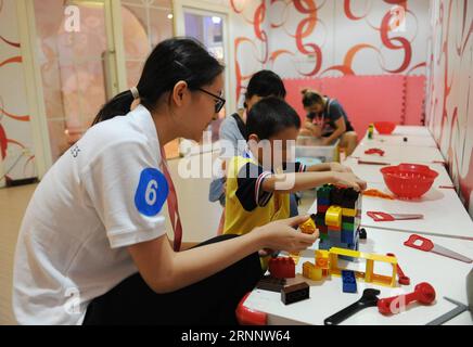 (170729) -- BEIJING, July 29, 2017 -- A volunteer joins the autistic children in playing with building blocks during an interactive game in a campaign to show love to the autistic children in Beijing July 29, 2017. ) (clq) CHINA-BEIJING-AUTISTIC CHILDREN-CARE(CN) RenxPengfei PUBLICATIONxNOTxINxCHN   Beijing July 29 2017 a Volunteer joins The Autistic Children in Playing With Building Blocks during to Interactive Game in a Campaign to Show Love to The Autistic Children in Beijing July 29 2017 CLQ China Beijing Autistic Children Care CN RenxPengfei PUBLICATIONxNOTxINxCHN Stock Photo