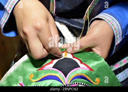(170823) -- QIANDONGNAN, Aug. 23, 2017 -- A woman embroiders patterns on traditional hundred-bird clothing in Baibei Village of Rongjiang County, southwest China s Guizhou Province, Aug. 22, 2017. The hundred-bird clothing, embroidered with colorful silk and bird feathers, is the traditional dress for festivals and important occasions of Miao ethnic group. It takes local people several months to make a piece of hundred-bird clothing. )(mcg) CHINA-GUIZHOU-RONGJIANG-MIAO ETHNIC GROUP-COSTUME (CN) WangxBingzhen PUBLICATIONxNOTxINxCHN   Qiandongnan Aug 23 2017 a Woman embroider patterns ON Traditi Stock Photo