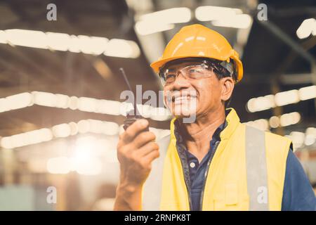 Asian adult foreman supervisor happy using radio control operate project work job in heavy industry factory Stock Photo