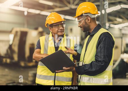 Asian male workers team work meeting talking consulting together in heavy industry factory Stock Photo