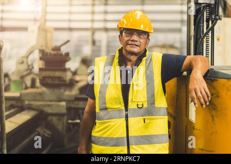 portrait happy senior Asian engineer worker adult staff working in heavy industry with safety Stock Photo