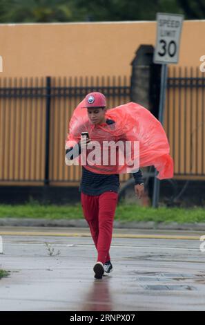 (170910) -- MIAMI, Sept. 10, 2017 -- A man walk in rain as hurricane Irma is approaching, in Miami, Florida, the United States, Sept. 9, 2017. About 5.6 million people in Florida have been ordered to evacuate, while 54,000 Floridians have taken shelter in 320 shelters across Florida. Forecasters expect the hurricane to hit Florida early Sunday morning. ) (srb) U.S.-MIAMI-HURRICANE-IRMA-APPROACHING YinxBogu PUBLICATIONxNOTxINxCHN Stock Photo