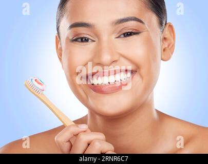 Happy portrait, woman and toothbrush on blue background for dental cleaning, gingivitis and beauty in studio. Model, toothpaste and brushing teeth Stock Photo