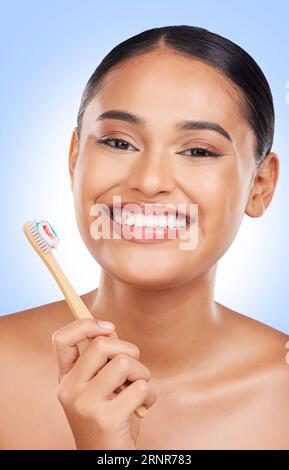 Happy woman, portrait and toothbrush in studio for dental cleaning, gingivitis or gums on blue background. Face of model, toothpaste and brushing Stock Photo