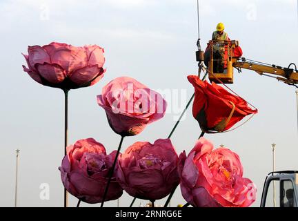 (170930) -- BEIJING, Sept. 30, 2017 () -- A worker puts final touches on a display in the shape of a flower basket at the center of the Tiananmen Square for the celebration of the National Day in Beijing, capital of China, Sept. 17, 2014. As a tradition since 2011, a giant flower basket with the theme of Good Luck, China is installed at the Tiananmen Square in central Beijing for the celebration of China s National Day on Oct. 1. This year, a 17-meter-tall basket with a diameter of 50 meters holds artificial flowers and fruits such as persimmons, pomegranates, apples, peonies and Chinese roses Stock Photo