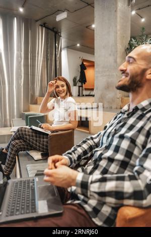 Side view photo of male and female coworkers having fun conversation and smiling during presentation Stock Photo
