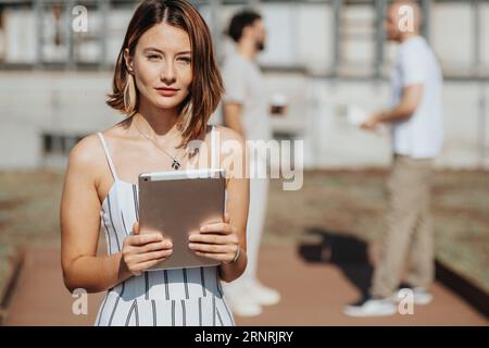 Stunning female architect holding tablet with blueprint on it. Portrait of female architect. Stock Photo