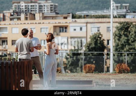 Architects discussing, analyzing blueprint on table. Construction engineers planning modern building design. Teamwork for successful architecture. Stock Photo