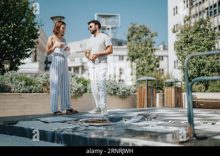 A team of architects and engineers discuss and plan a modern building project outdoors, focusing on collaboration and successful urban design. Stock Photo