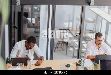 A confident business group in a modern office, analyzing stats, working together, using technology for digital marketing and project development. Stock Photo
