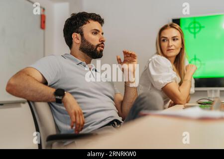 A diverse business team in a modern office, discussing analytic and profit growth. Multiracial and multicultural, they work together on project develo Stock Photo