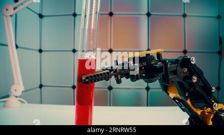 a robot holds a sample of a chemical substance the concept of using robotics in laboratory work Stock Photo