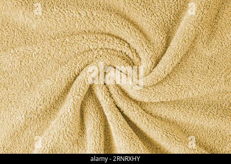 Terry cloth, yellow towel texture background. Wrinkled and crumped soft fluffy textile bath or beach towel material. Top view, close up. Stock Photo