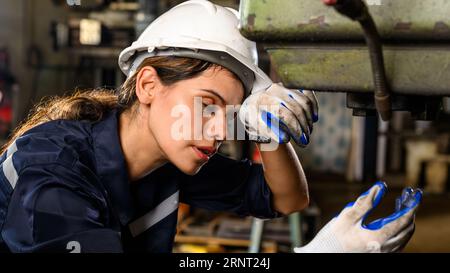 Unhappy mechanical engineer female with problem at factory, Tired worker with hardworking job at industrial plant, High quality photo Stock Photo