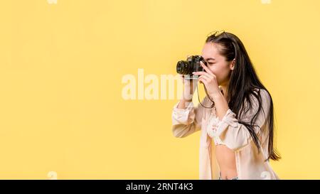 Long haired woman holding camera taking picture Stock Photo