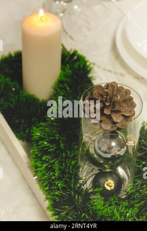 Decorative table composition for Christmas dinner or food, with Christmas balls, candles and pine cones Stock Photo