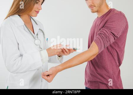 Female doctor taking blood from patient Stock Photo