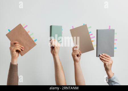 People holding books with colorful reminders stickers Stock Photo