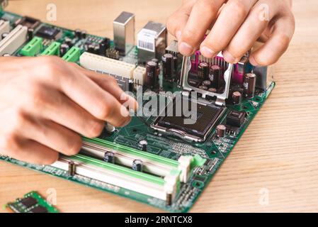 Close up male technician repairing cpu socket wooden table Stock Photo