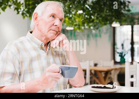 Thoughtful elderly man drinking tea Stock Photo
