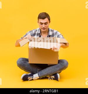 Front view man opening delivered package Stock Photo