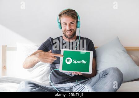 Young man holding tablet with spotify app Stock Photo