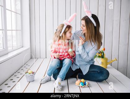 Girl mother having fun while painting eggs easter Stock Photo