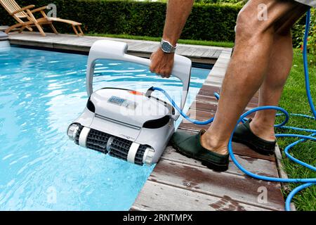 Cleaning robot ensures clear water and cleanliness in private swimming pool, Germany Stock Photo