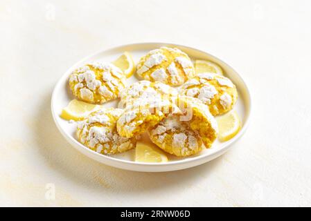 Homemade lemon crinkle cookies on plate over light background. Close up view Stock Photo