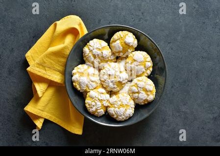 Lemon crinkle cookies ib bowl over dark stone background. Top view, flat lay Stock Photo