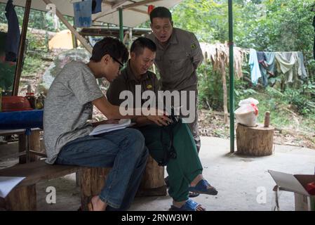 (171202) -- HAIKOU, Dec. 2, 2017 -- Members of Hainan gibbon monitoring team check photos of Hainan gibbons in the Bawangling National Nature Reserve in Changjiang, south China s Hainan Province, Oct. 27, 2017. The Hainan gibbon, or Nomascus Hainanus, is the world s rarest primate, and probably rarest mammal species. Once numbered around 2,000 in the 1950s, they underwent a sharp decline in the late 20th century largely due to habitat loss and hunting. Typically living in rainforest trees over 10 meters tall, the Hainan black crested gibbon (Nomascus hainanus), with long arms and legs but no t Stock Photo