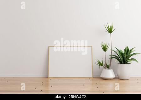 Horizontal wooden photo frame mockup on white wall empty room with plants on a wooden floor Stock Photo
