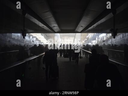 (171209) -- URUMQI, Dec. 9, 2017 -- Passengers go through the underpass to board the Train No. 5810 linking Kashgar and Hotan at Hotan Railway Station in northwest China s Xinjiang Uygur Autonomous Region, Nov. 25, 2017. The 485-km train route linking two major oasis towns Kashgar and Hotan, runs through some of the remotest areas in Xinjiang, and has transformed life in the desert since its launch in 2011. It is the first and only railway in Hotan, via the railway the underdeveloped prefecture is linked to the rest of the country s rail network, which boasts 22,000 km of high-speed railway li Stock Photo