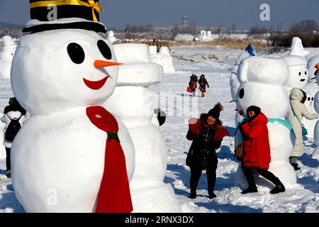 (180111) -- HARBIN, Jan. 11, 2018 -- People pose for photos with snowman sculptures at an ice and snow park in Harbin, capital of northeast China s Heilongjiang Province, Jan. 11, 2018. Altogether 2,018 cute snowmen were displayed here to greet the year 2018. ) (zwx) CHINA-HARBIN-SNOWMAN (CN) WangxKai PUBLICATIONxNOTxINxCHN Stock Photo