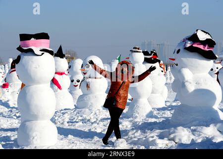(180111) -- HARBIN, Jan. 11, 2018 -- A tourist poses for photos with snowman sculptures at an ice and snow park in Harbin, capital of northeast China s Heilongjiang Province, Jan. 11, 2018. Altogether 2,018 cute snowmen were displayed here to greet the year 2018. ) (zwx) CHINA-HARBIN-SNOWMAN (CN) WangxKai PUBLICATIONxNOTxINxCHN Stock Photo