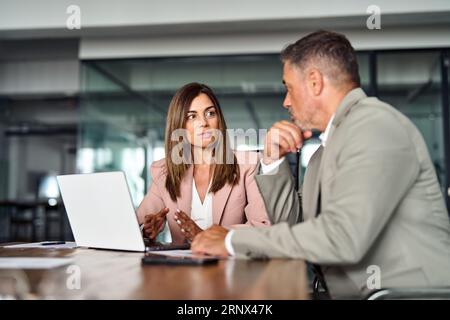 Busy executives using laptop discussing digital project at office meeting. Stock Photo