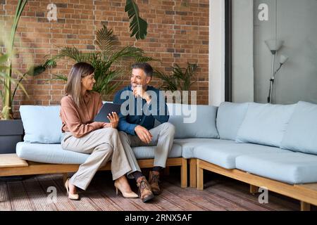 Two happy professional business executives talking using tablet in office. Stock Photo