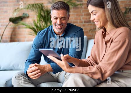 Two happy professional business executives using tablet in office. Stock Photo