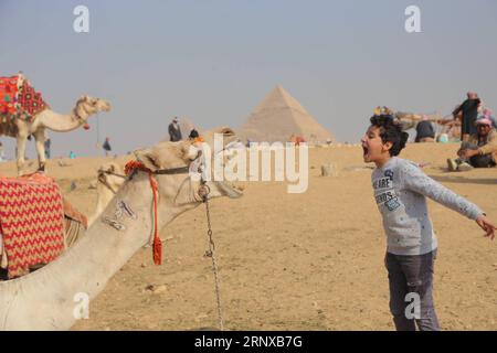(180120) -- GIZA (EGYPT), Jan. 20, 2018 -- An Egyptian boy plays with a camel near the Pyramids of Giza on the outskirts of Cairo, Egypt, on Jan. 20, 2018. ) EGYPT-GIZA-PYRAMIDS-TOURISM AhmedxGomaa PUBLICATIONxNOTxINxCHN Stock Photo