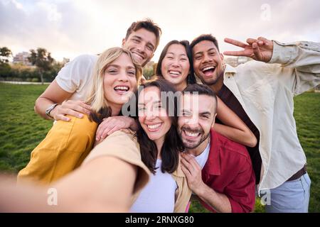 Group of young cheerful multi-ethnic friends taking selfie with mobile phone outdoor. Happy people. Stock Photo