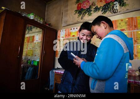 (180206) -- KANGLE, Feb. 6, 2018 -- Sun Jianjun (L) and his younger brother Sun Jianqiang play in Xinzhuang Village, Basong Township, Kangle County of northwest China s Gansu Province, Feb. 2, 2018. Spring Festival, or Chinese Lunar New Year, falls on Feb. 16 this year. Hundreds of millions of Chinese will return to their hometowns for family gatherings. 14-year-old Sun Jianjun and his 15 schoolmates are among these travellers eager back to home. On Feb. 1, the first day of the 2018 Spring Festival travel rush, they stepped onto a train in Nantong of east China s Jiangsu Province on a journey Stock Photo