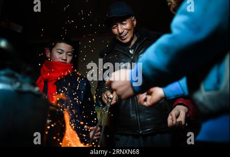 (180206) -- KANGLE, Feb. 6, 2018 -- Sun Jianjun keeps warm by the fire at home in Xinzhuang Village, Basong Township, Kangle County of northwest China s Gansu Province, Feb. 2, 2018. Spring Festival, or Chinese Lunar New Year, falls on Feb. 16 this year. Hundreds of millions of Chinese will return to their hometowns for family gatherings. 14-year-old Sun Jianjun and his 15 schoolmates are among these travellers eager back to home. On Feb. 1, the first day of the 2018 Spring Festival travel rush, they stepped onto a train in Nantong of east China s Jiangsu Province on a journey to home that is Stock Photo