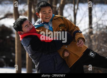 (180206) -- KANGLE, Feb. 6, 2018 -- Sun Jianjun (L) and his younger brother Sun Jianqiang play in Xinzhuang Village, Basong Township, Kangle County of northwest China s Gansu Province, Feb. 3, 2018. Spring Festival, or Chinese Lunar New Year, falls on Feb. 16 this year. Hundreds of millions of Chinese will return to their hometowns for family gatherings. 14-year-old Sun Jianjun and his 15 schoolmates are among these travellers eager back to home. On Feb. 1, the first day of the 2018 Spring Festival travel rush, they stepped onto a train in Nantong of east China s Jiangsu Province on a journey Stock Photo